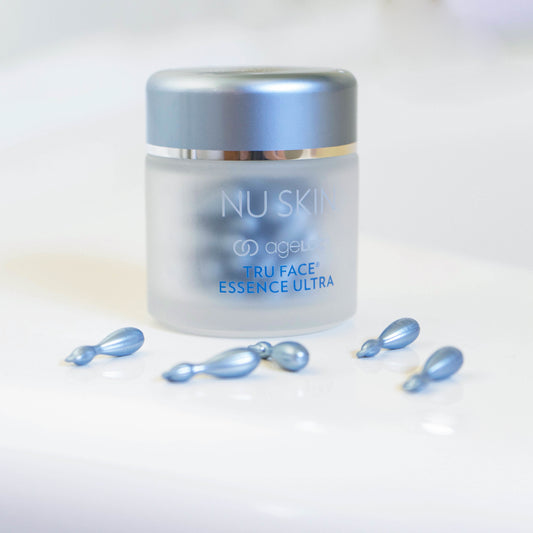 Nu Skin ageLOC Tru Face Essence Ultra jar with blue single-use serum capsules arranged on a white background.